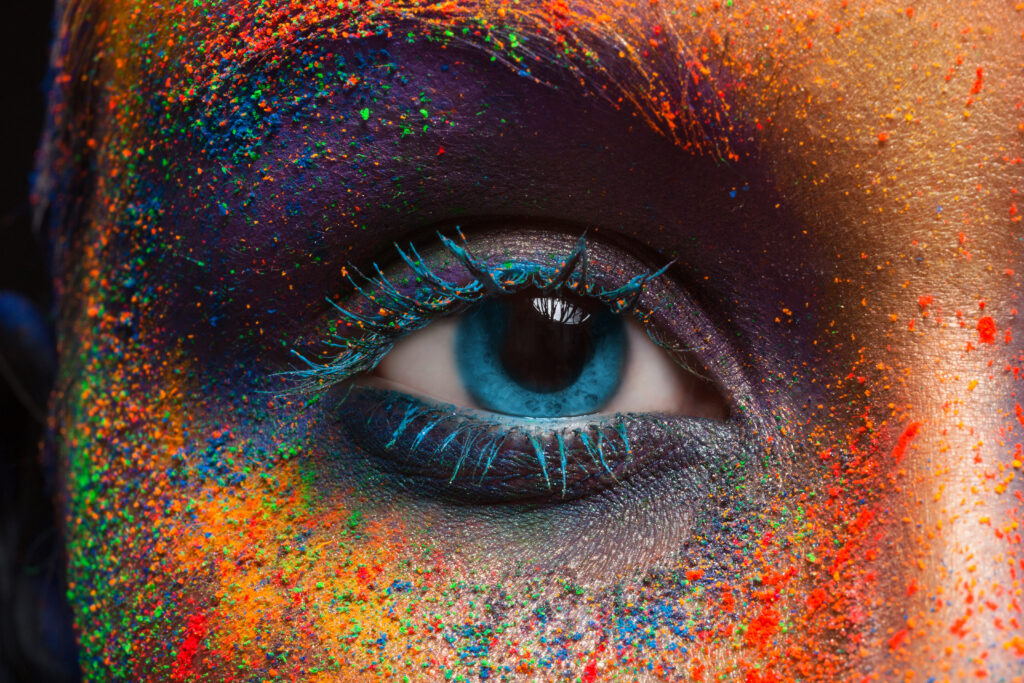 Crop of female eye with colorful make up. Beautiful fashion model with creative art makeup. Abstract colorful splash make-up. 
